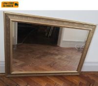 A contemporary mirror in a gilt frame with incised scrolling foliate decoration. 89x64cm.