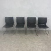 A set of four contemporary black composite moulded and bent chrome stacking chairs by Connection