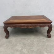 A 20th century Chinese hardwood low Kang coffee table with plank top over the carved apron raised on