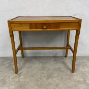 A mid century teak side or writing table on square section stretchered supports. H.68 W.77 D.41cm.