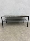 A contemporary coffee table with faux marble top raised on straight supports united by a wirework