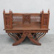 A 20th century Indian teak elephant howdah saddle chair with carved panel back and turned spindle