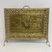 A vintage embossed brass fire screen with central genre style figure group within a stylised