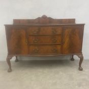 An early to mid 20th century mahogany serpentine sideboard or buffet with shaped gallery back over