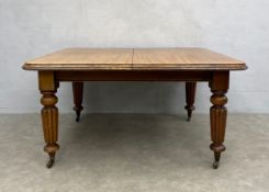 A William IV mahogany extending dining table with wind-out mechanism raised on tapering reeded
