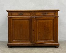 A 19th century Louis Philippe style oak sideboard with two frieze drawers over panel doors enclosing