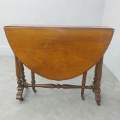 A Victorian mahogany drop leaf Sutherland table with circular thumb-moulded top raised on turned and