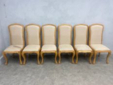 A set of six French Provincial style light oak dining chairs with carved frames on cabriole