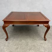 A Georgian style teak extending dining table with two extra leaves on shell carved cabriole