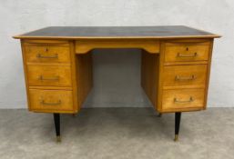 A 1950/60s pedestal desk with black leather lined top over brushing slides and pedestal drawers