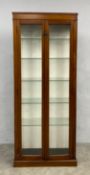 An early 20th century mahogany vitrine or display cabinet with glazed doors enclosing six shelves