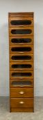 A 20th century oak haberdashery cabinet with six glazed and two base drawers raised on a plinth