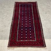 An Afghan style Bukhara carpet with four rows of eighteen guls over a midnight ground within