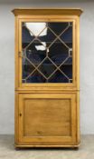 A Georgian pine full height corner cabinet with glazed section above panel door on turned bun