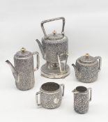 A late 19th century Victorian hallmarked kutch silver repousse tea set comprised of a spirit kettle,