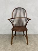 A 19th century stick back Windsor chair with spindle back and arms over the shaped saddle seat