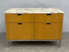 A contemporary filing cabinet with marble top over frieze drawers raised on straight chrome supports