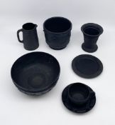A collection of 19th century black basalt stoneware pottery with moulded neoclassical scenes to