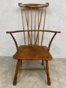 A 19th century oak and elm comb-back Windsor armchair with high stick back and shaped arms over