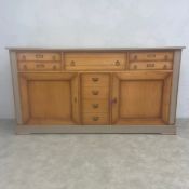 A contemporary walnut Hauteville sideboard with panel top over an arrangement of cupboards and