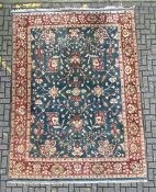 A large Persian Mahal carpet with scrolling foliate field over a teal ground within similarly