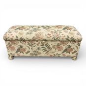 A contemporary upholstered ottoman in flowerhead tapestry style upholstery. H.48 W.108 D.40cm.