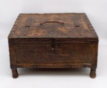 A 19th century metal bound and carved Indian hardwood merchants chest with partially hinged lid