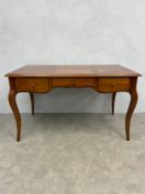 A contemporary Louis XV style cherrywood writing table with parquetry top and maker's plaque