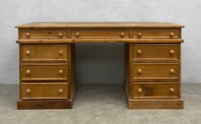 A 20th century pine twin pedestal desk with three frieze drawers over six short pedestal drawers