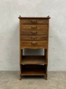 A late 19th century walnut music or stationery cabinet fitted with fall-front drawers and Art