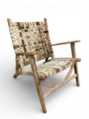 A contemporary carved hardwood armchair with woven cowhide back and seat by Oficina De Agosto with