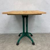 A 20th century bistro table with square plank top raised on a cast and painted iron quadruped base