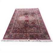 A large contemporary Kirman carpet with allover scrolling polychrome panel field over an abrash