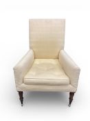 An early 19th century library armchair with fitted buttoned cushion on turned supports terminating