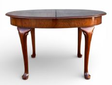 A mid century Georgian style mahogany extending dining table having a circular top with two