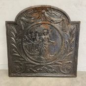 A 19th century cast iron fire back with central figural cartouche within a laurel wreath and garland