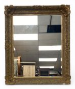 A 19th century gilt mirror with scrolling foliate gesso decoration with bevelled plate. H.112 W.93