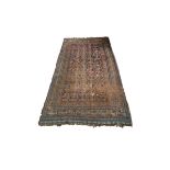 A large Persian Baluch carpet with five rows of sixteen polychrome guls over a midnight blue