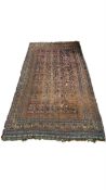 A large Persian Baluch carpet with five rows of sixteen polychrome guls over a midnight blue
