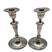 A C.1900 pair of sterling silver candlesticks with fluted stems and lobed circular bases by
