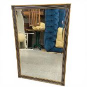 A contemporary Art Deco style wall mirror with bevelled plate in a reeded gilt frame. 94x63cm.