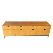 A contemporary pale birch credenza with an arrangement of eight filing drawers raised on straight