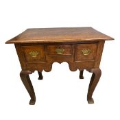 A Georgian oak lowboy with plank top over three frieze drawers raised on square section cabriole