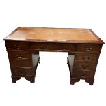 An mid 20th century Georgian style mahogany twin pedestal desk with gilt and tooled tan leather