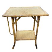 A vintage bamboo occasional table with woven rattan top raised on splayed supports united by an