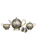 A vintage Art Deco style pewter tea set to include a teapot, sugar pot, creamer and salt and