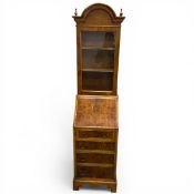 A narrow early Georgian style yewwood bureau bookcase having an arched pediment with brass ball