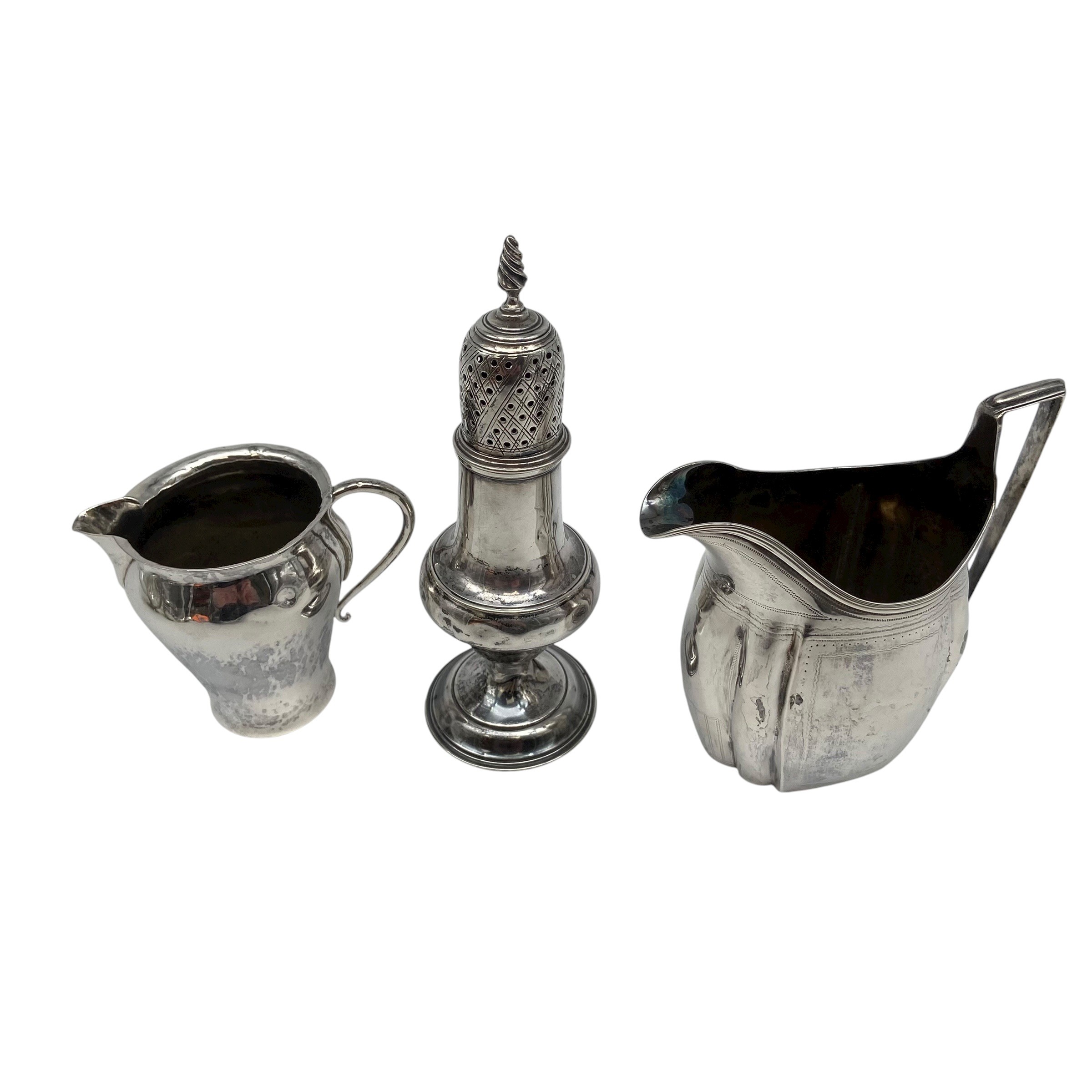 An Arts & Crafts hammered sterling silver creamer by Birmingham Guild of Handicraft Ltd, 1903