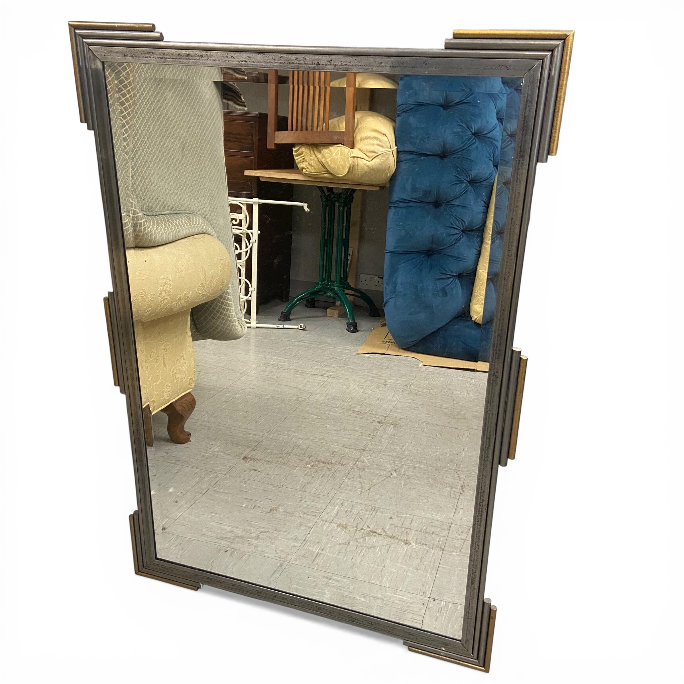 A contemporary Art Deco style wall mirror with rectangular bevelled plate in the distressed metal