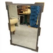 A contemporary Art Deco style wall mirror with rectangular bevelled plate in the distressed metal